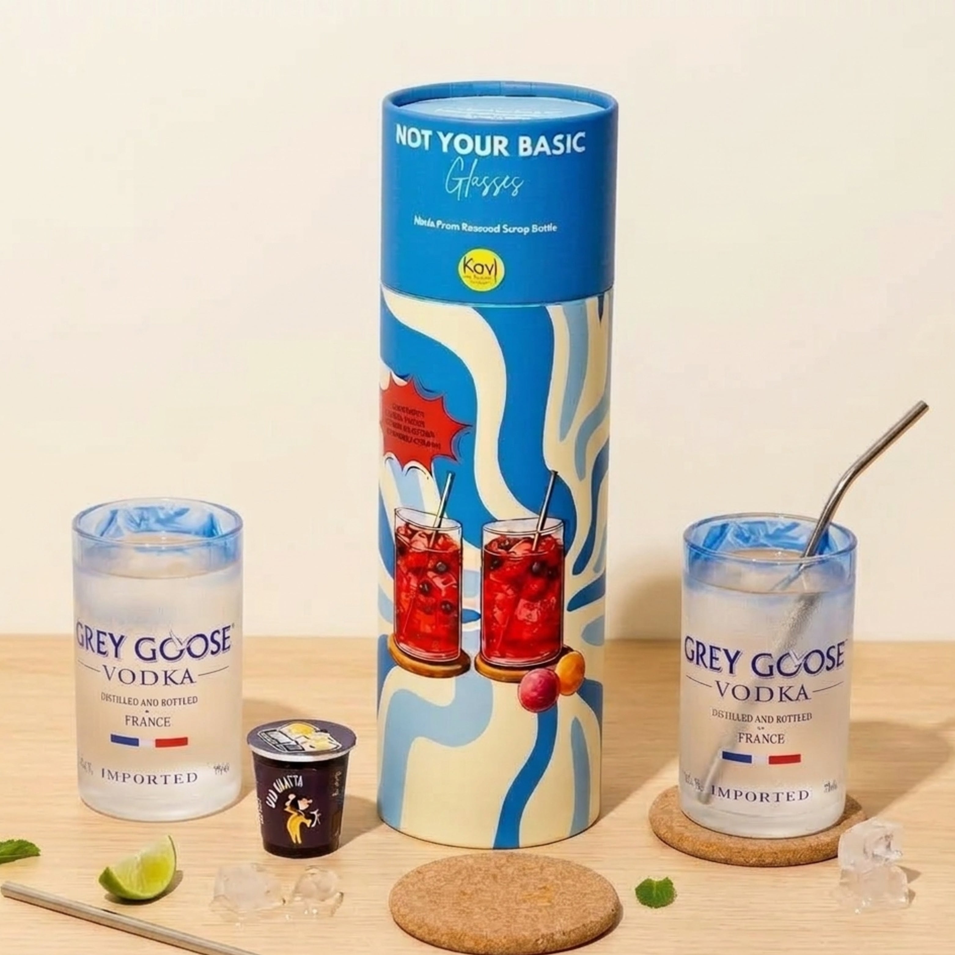 Gray Goose vodka with a cylindrical Kool-Aid container on a wooden surface.